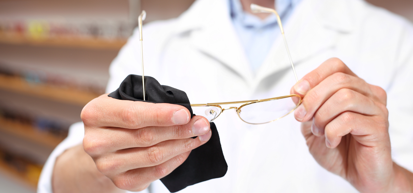 Optometrist uses cloth to wipe eyeglasses clean