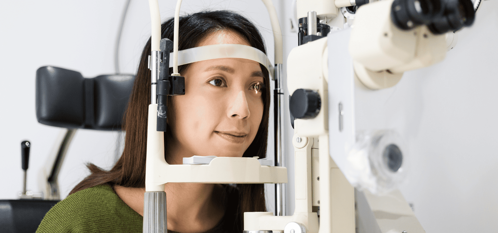 Woman receiving a eye scan in medical office with eye scanning device