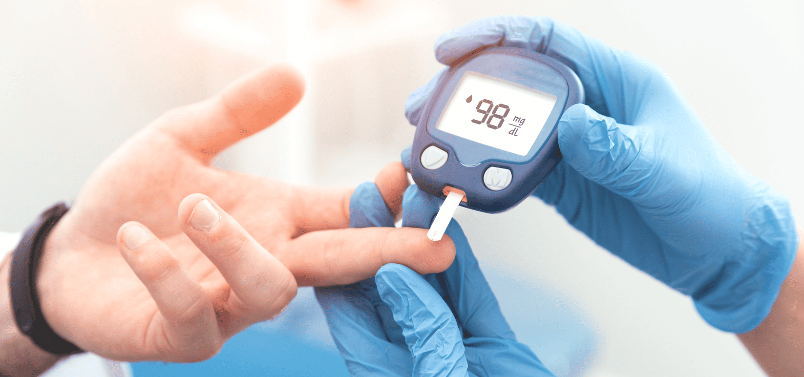 medical professional checking blood sugar levels of patient by pricking finger
