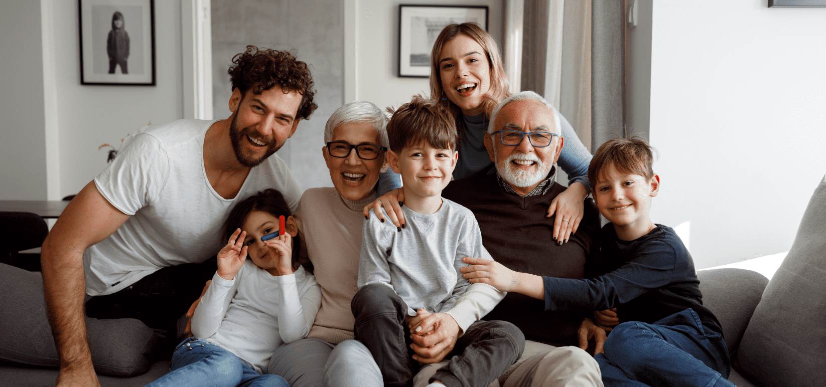 Family portrait with 3 generations where the grandparents are wearing glasses